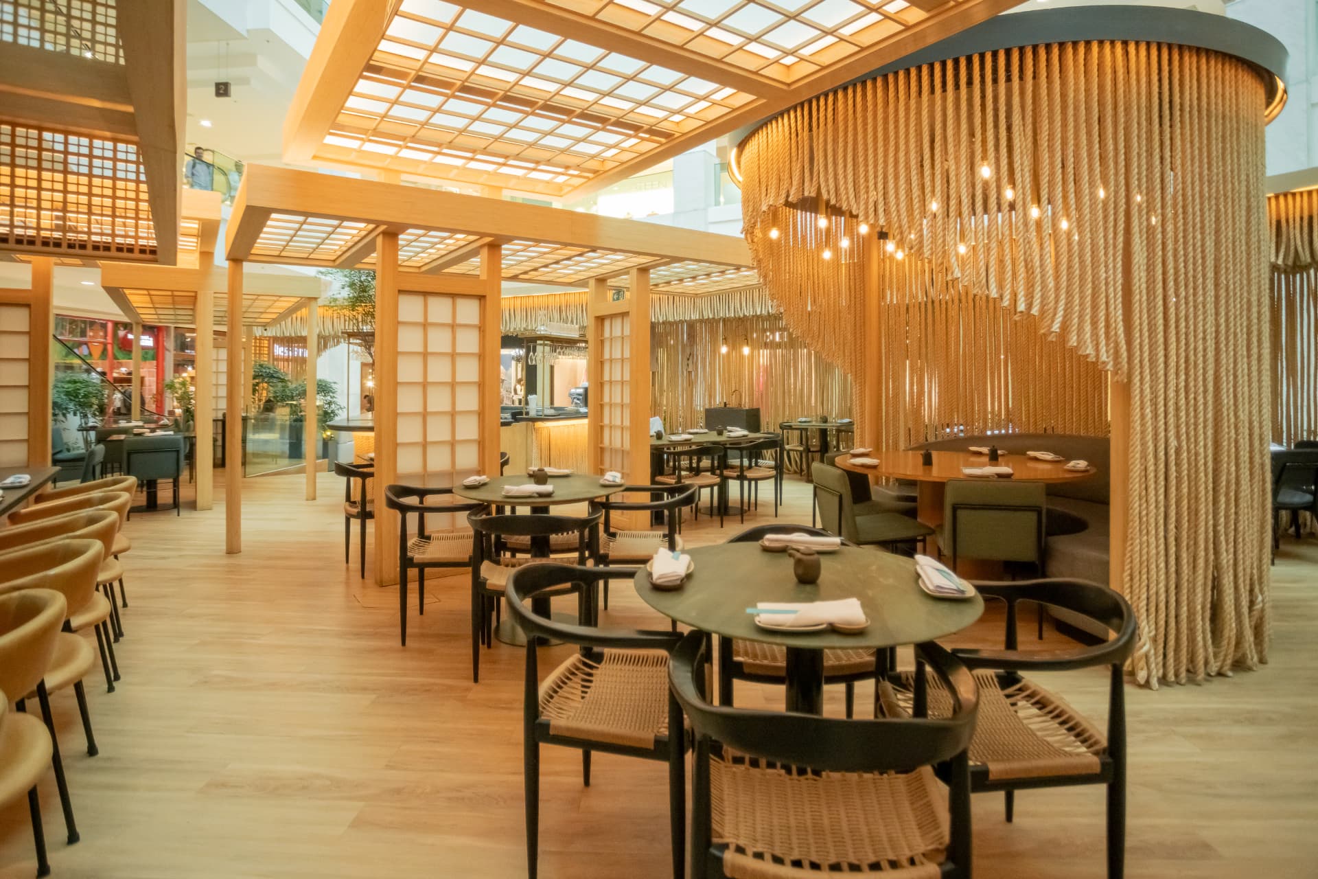 Ambiente do Kitchin Leblon com madeira clara e luz natural