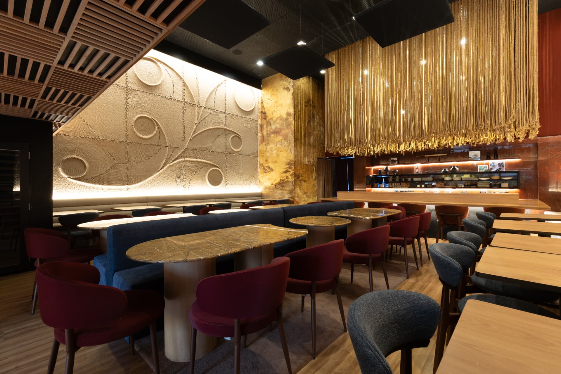 Salão do Kitchin Itaim com painel iluminado e mesas