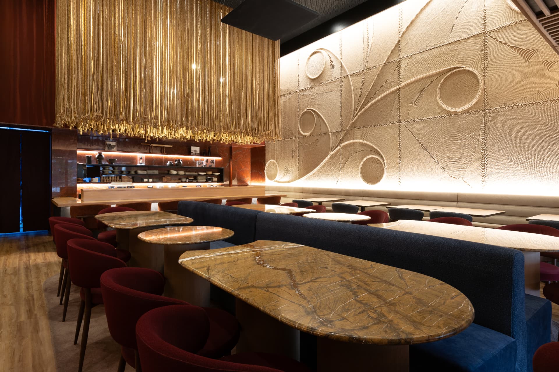 Salão do Kitchin Itaim com painel iluminado ao fundo